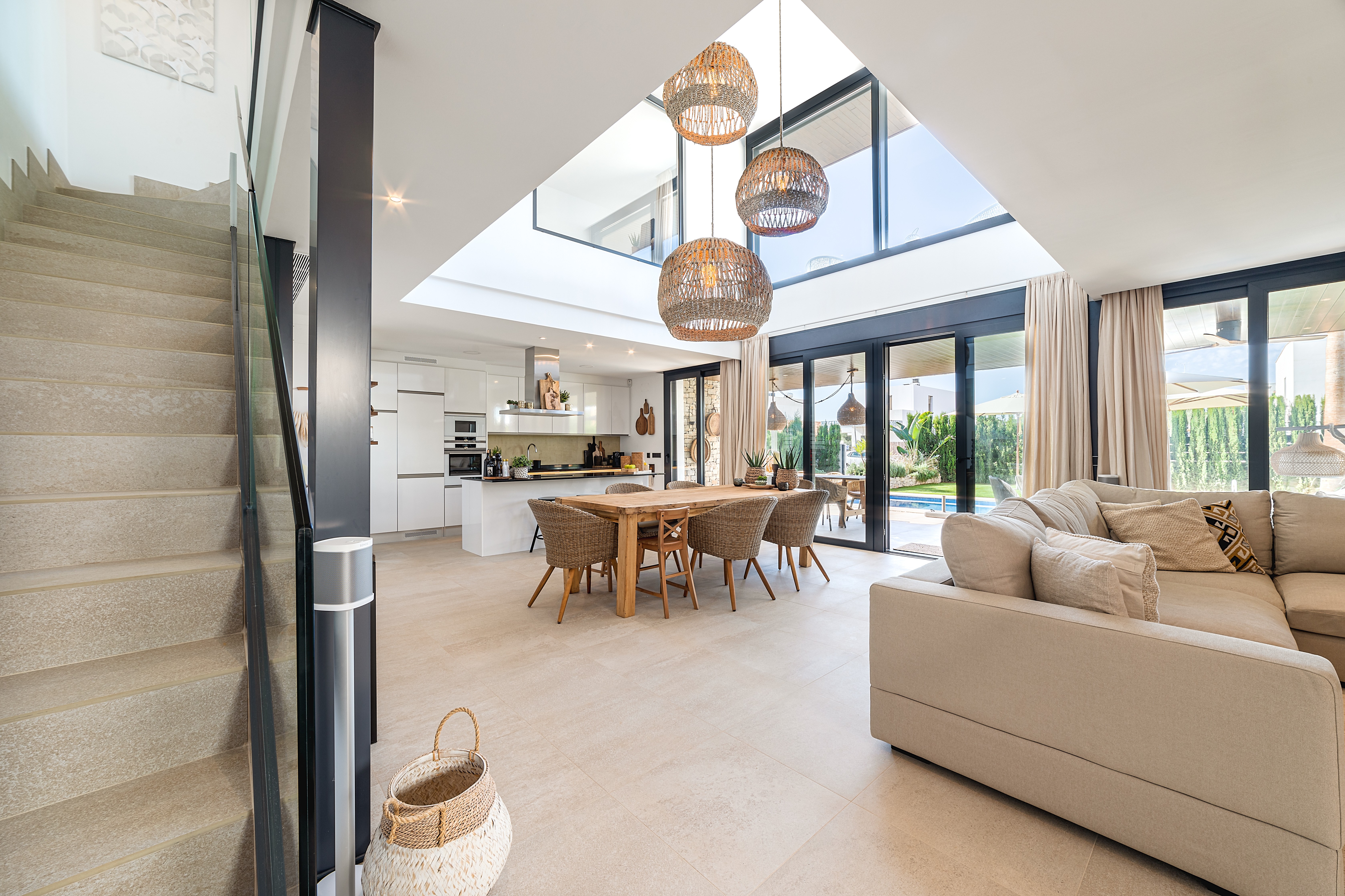 Essbereich der Beachhouse Villa in Sa Ràpita mit grossen Fensterfronten, Holztisch und fliessendem Übergang zum Aussenbereich