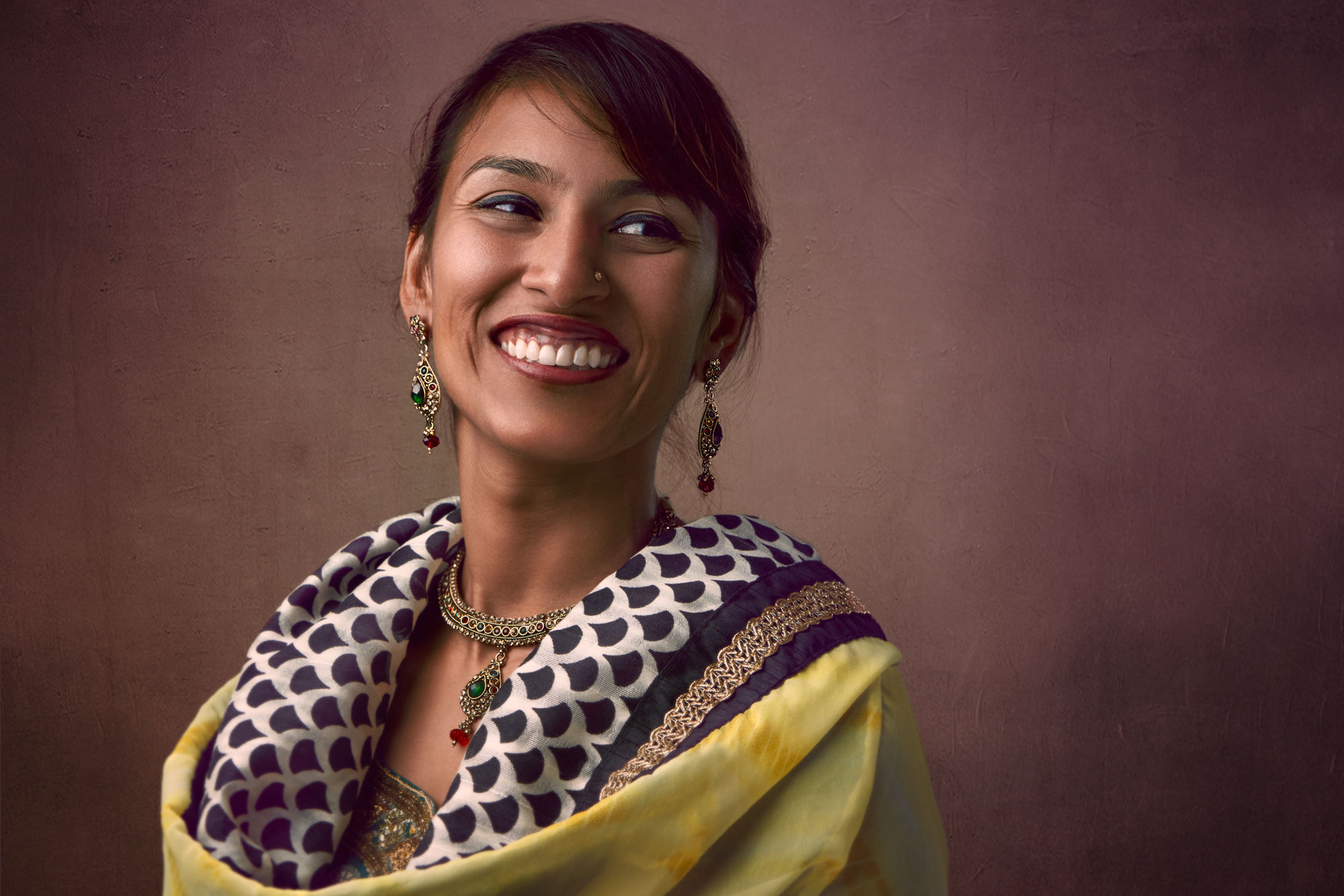Natural light portrait of South Asian woman smiling with scarf