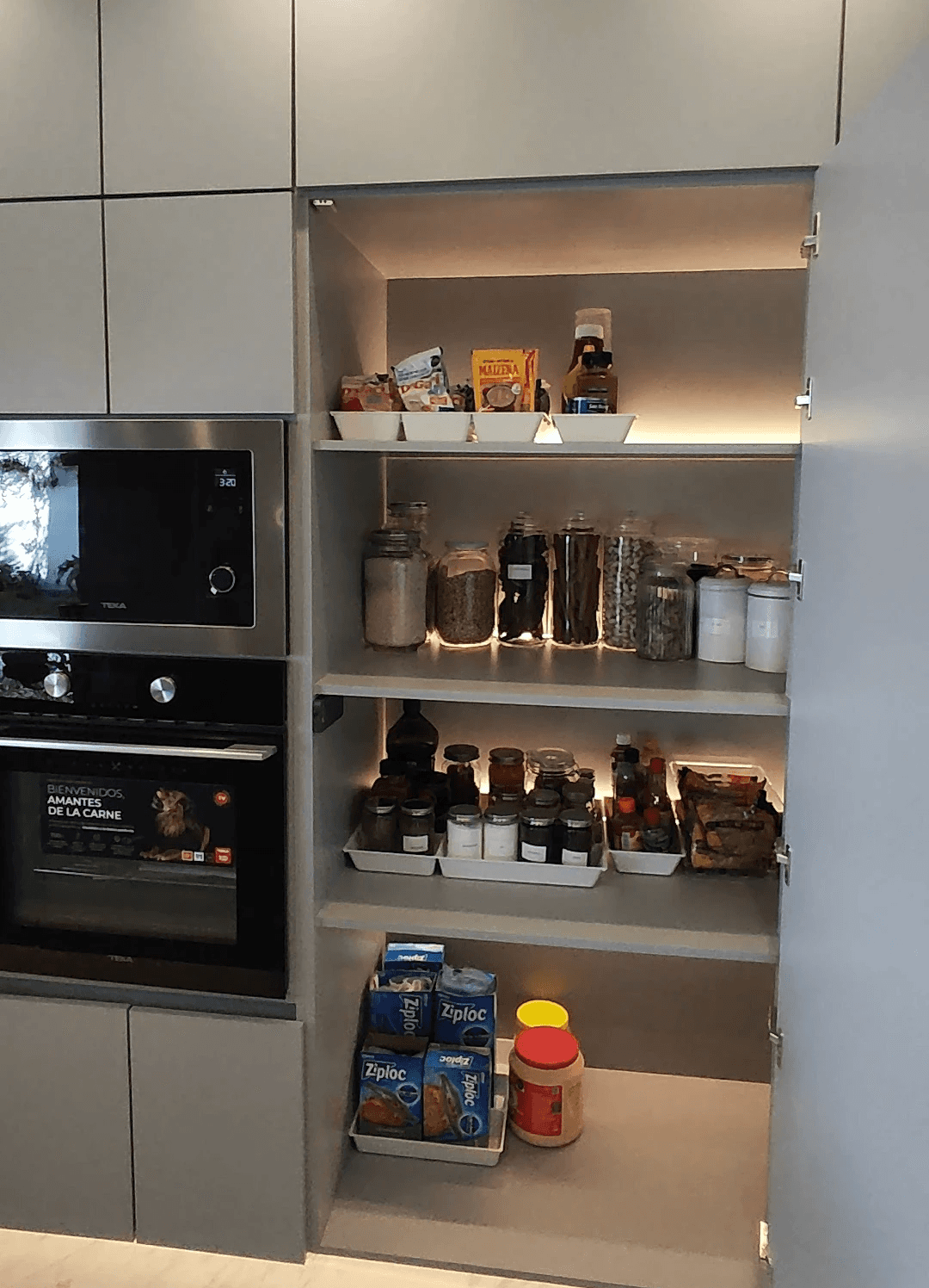 A serene outdoor lounge area with two chairs surrounded by lush greenery and natural light streaming in.