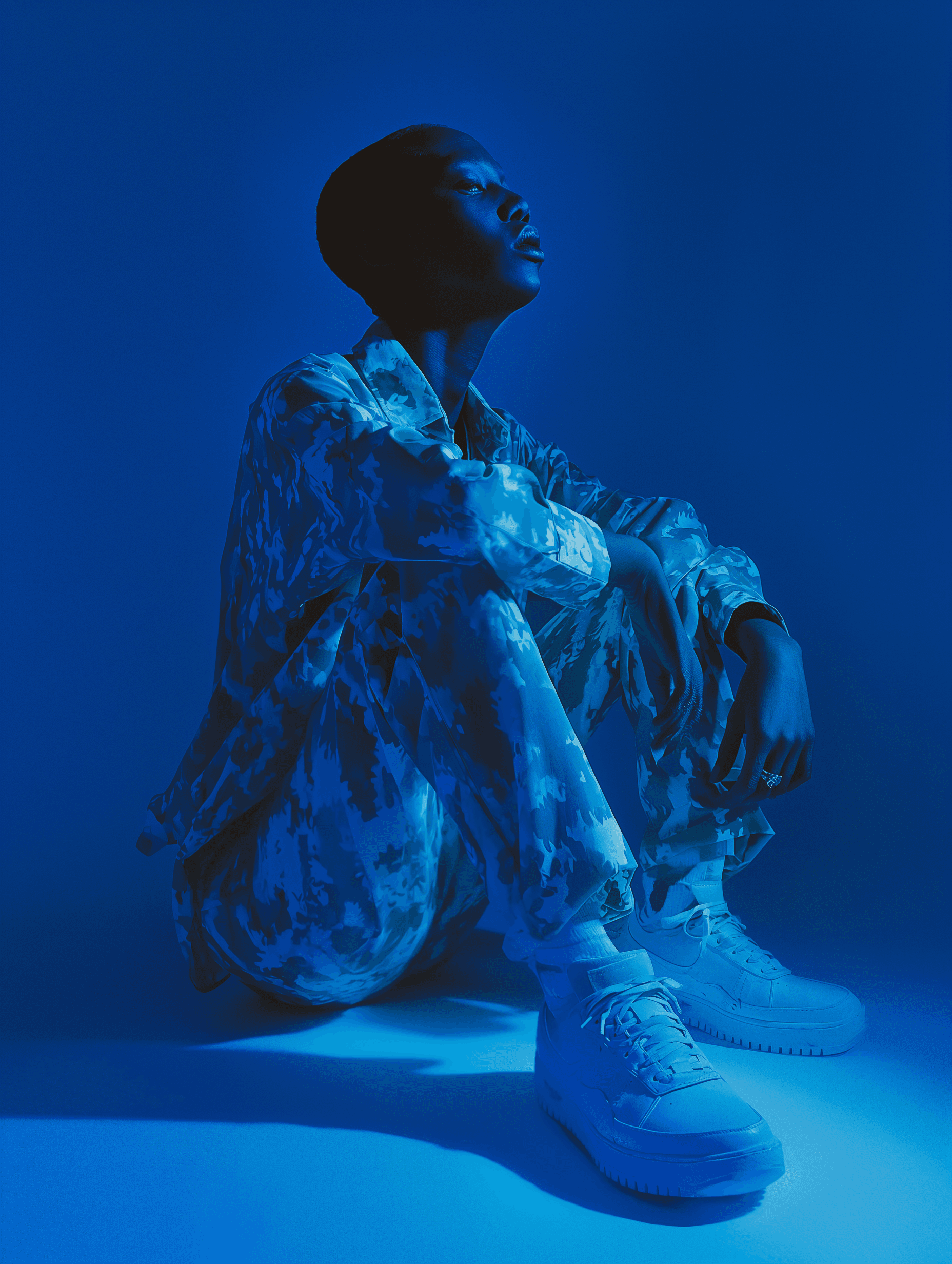 aesthetic blue photo of a sitting woman in military clothing