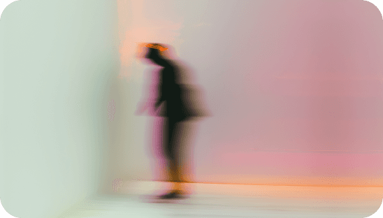 Soft-focus silhouette of a person standing in pastel light