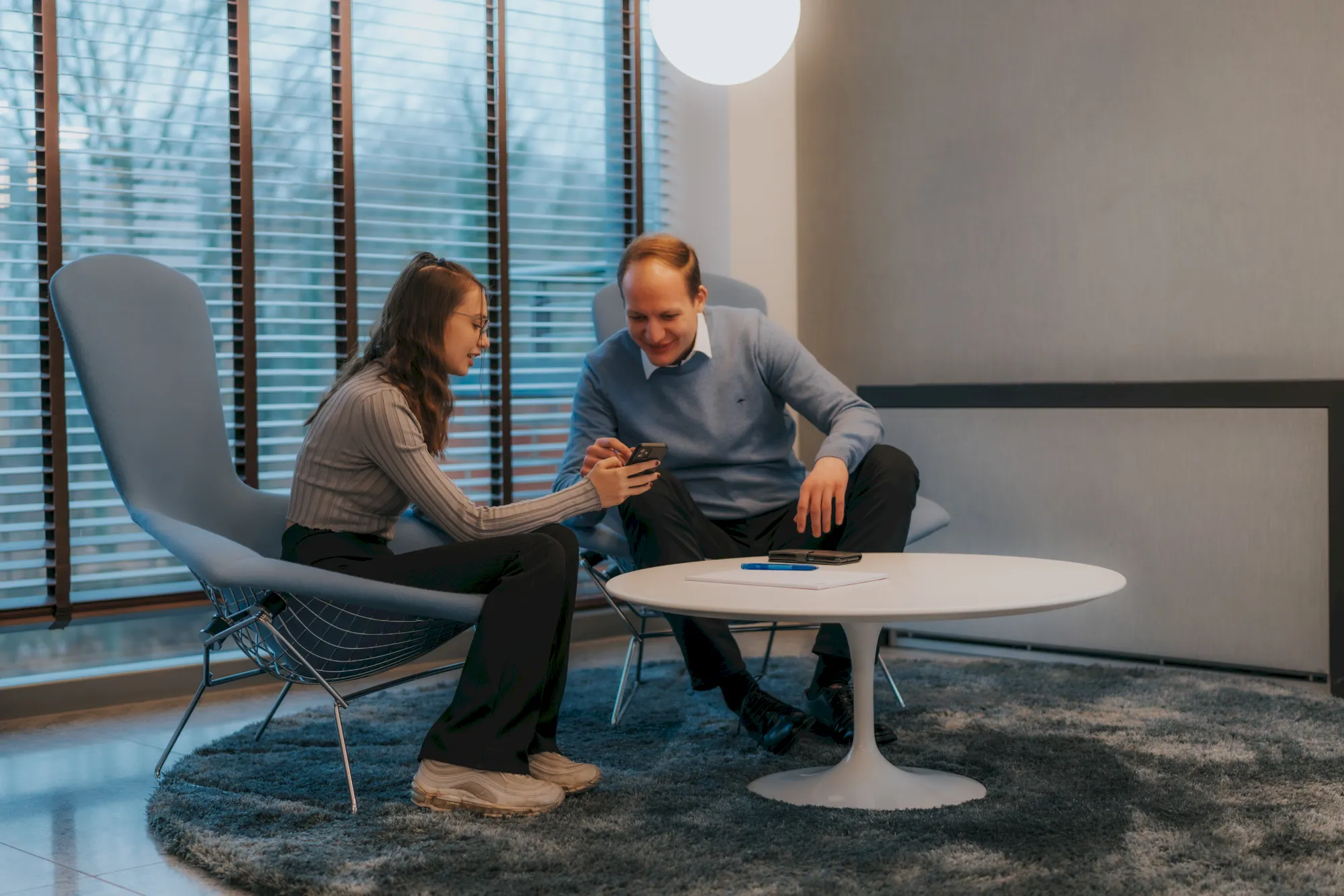 Zwei Personen im Gespräch bei einer Sitzung. Zusammenarbeit und Austausch in modernem Büro