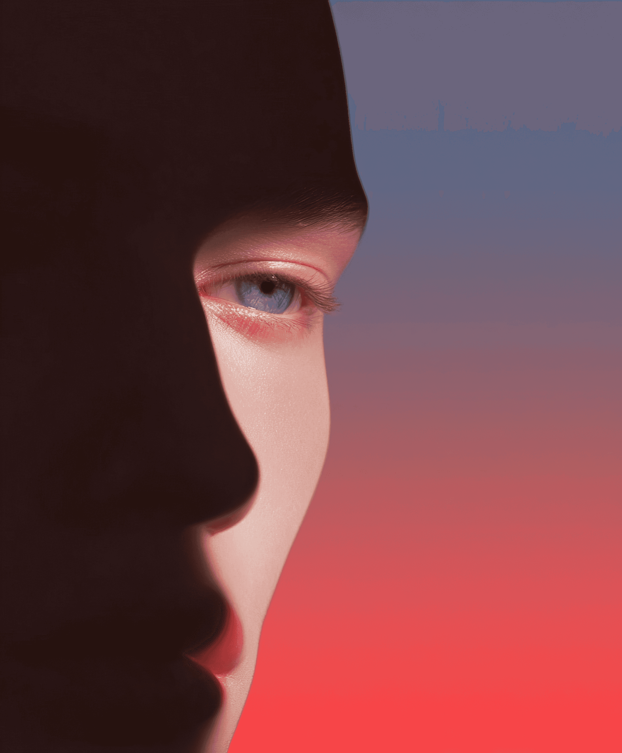 Half of a face in shadow under pink-red light