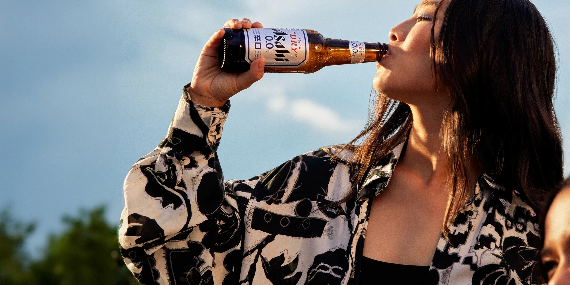 Woman drinking Asahi zero alcohol beer