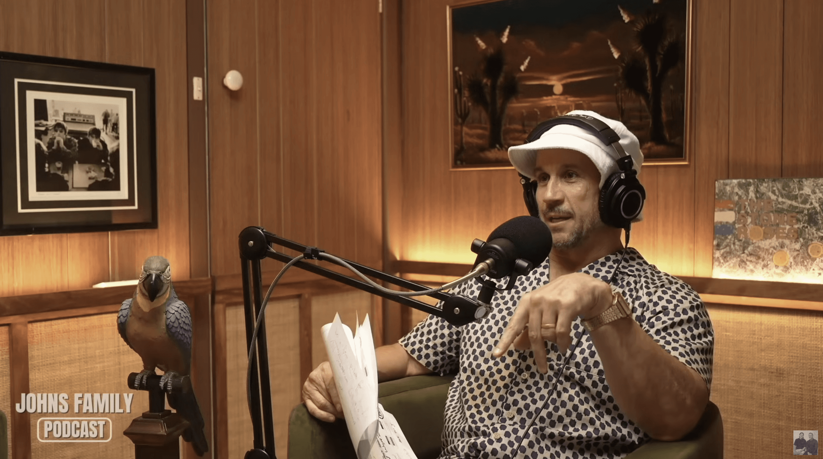 Matty Johns speaking into miscrophone in studio set