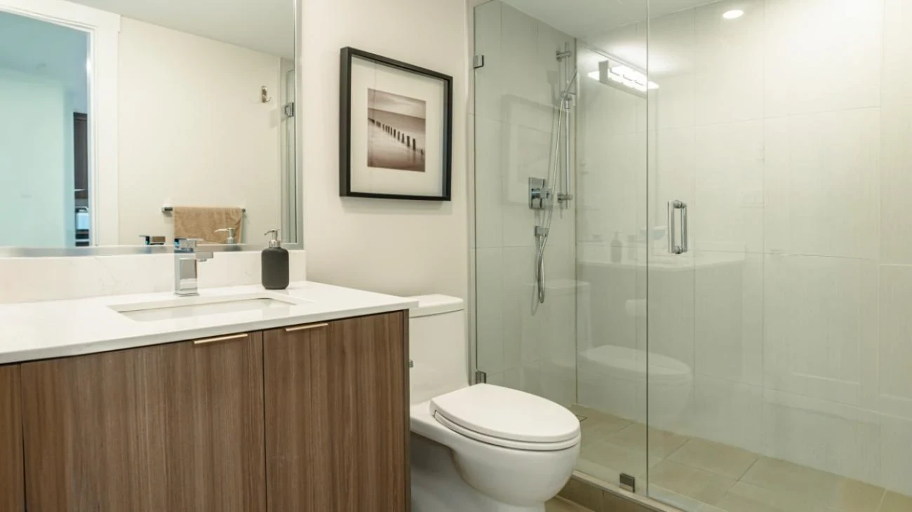 Luxury ensuite bathroom featuring wooden vanity, glass shower enclosure, and modern fixtures in Burnaby custom home