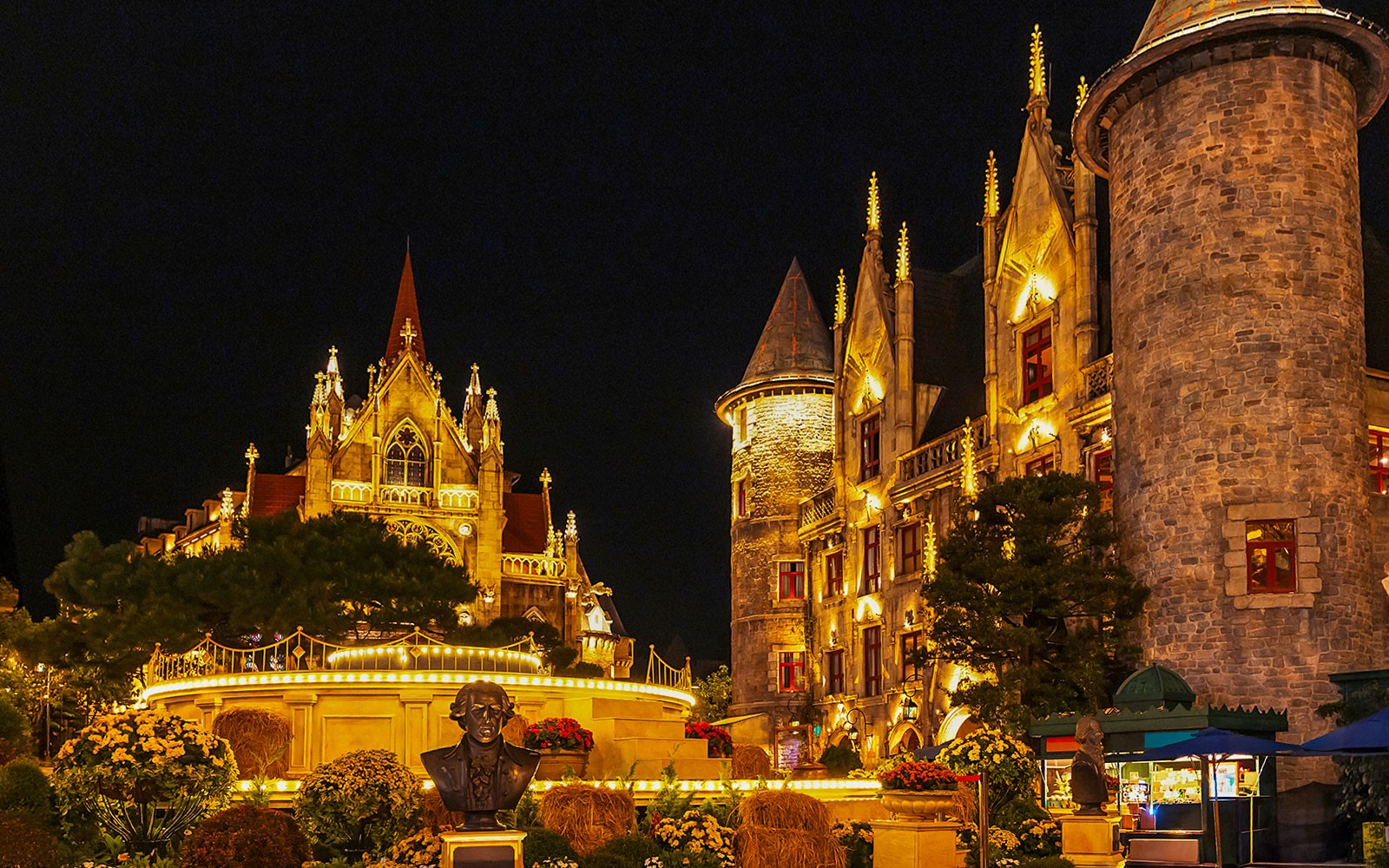 Catholic Cathedral and stone castle illuminated at night in Ba Na Hills Park, Da Nang, Vietnam.