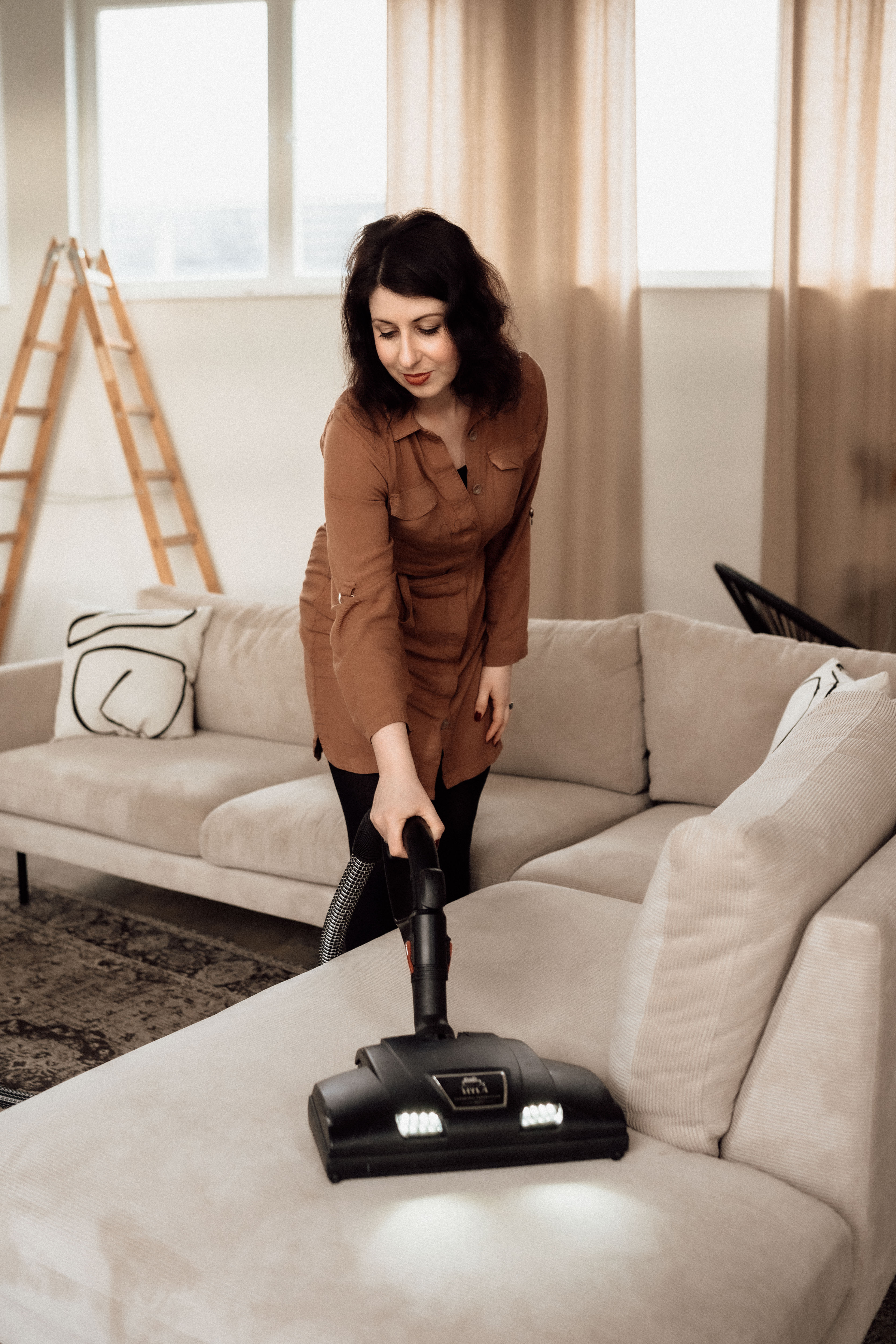 eine Frau, die mit dem HYLA eine Polsterreinigung durchführt