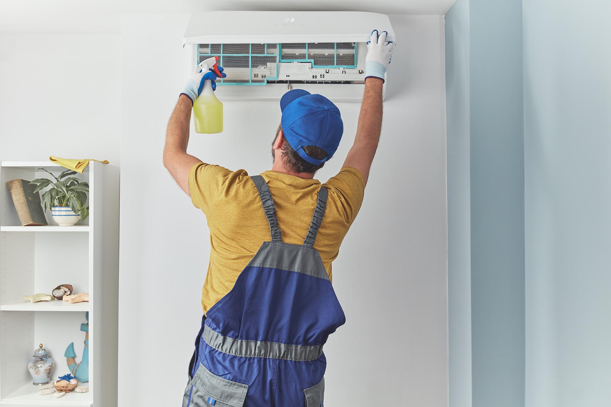 An Adams Care expert technician doing a regular maintenance to avoid bad smell coming from air conditioner