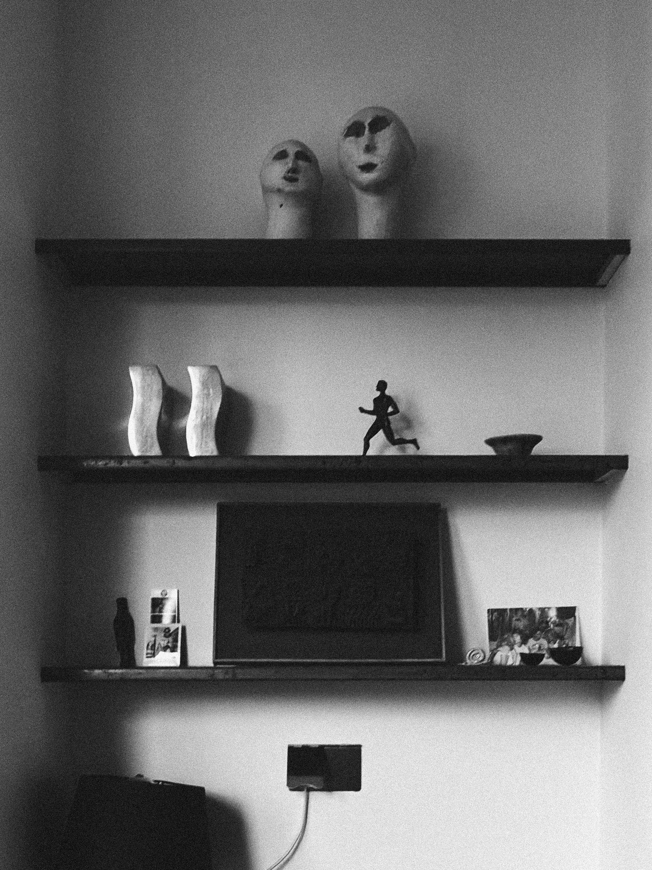 Minimal black shelving with curated objects and soft shadow detail