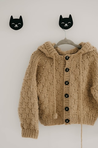 Beige textured knit sweater hanging on wall