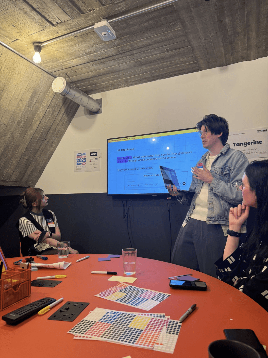 Max presenting in front of a screen at UX Camp