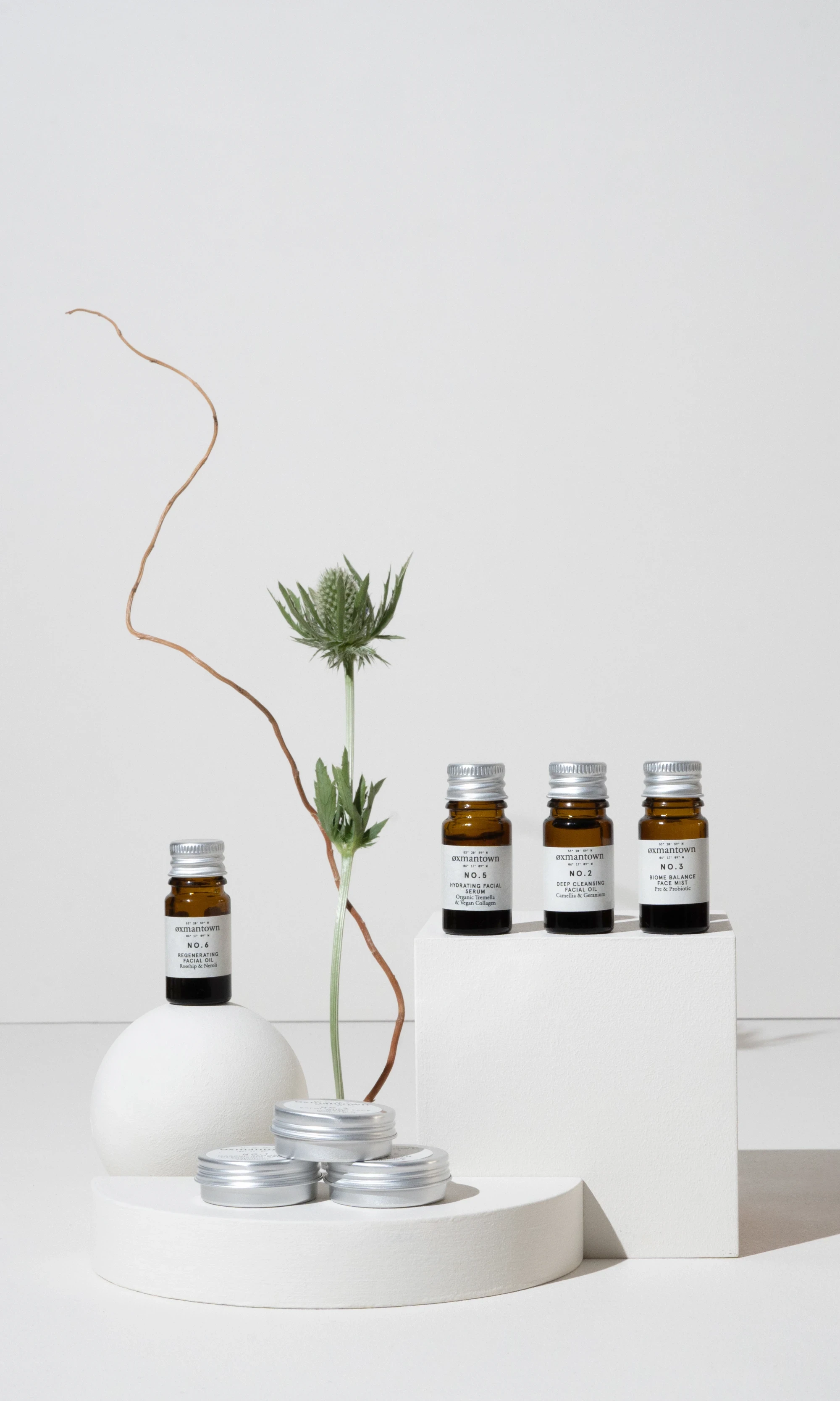 Collection of small sample bottles with printed labels on them in a photoshoot setupw ith white backgrounds