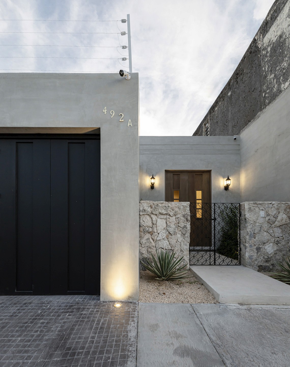 Casa Jacinta - Entrada, muro de piedra, gravilla, concreto pulido