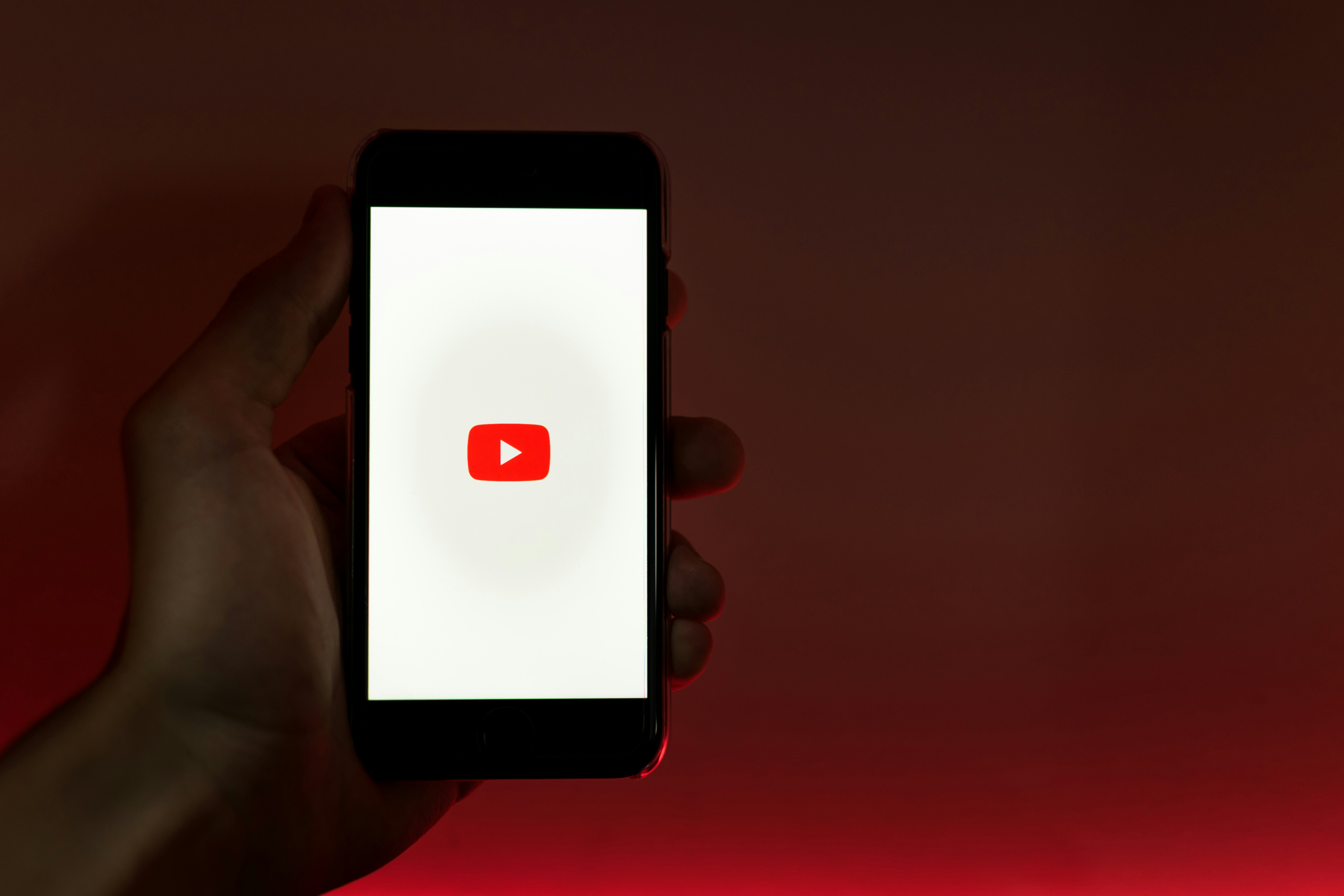 person holding phone with youtube - Promote Music On YouTube