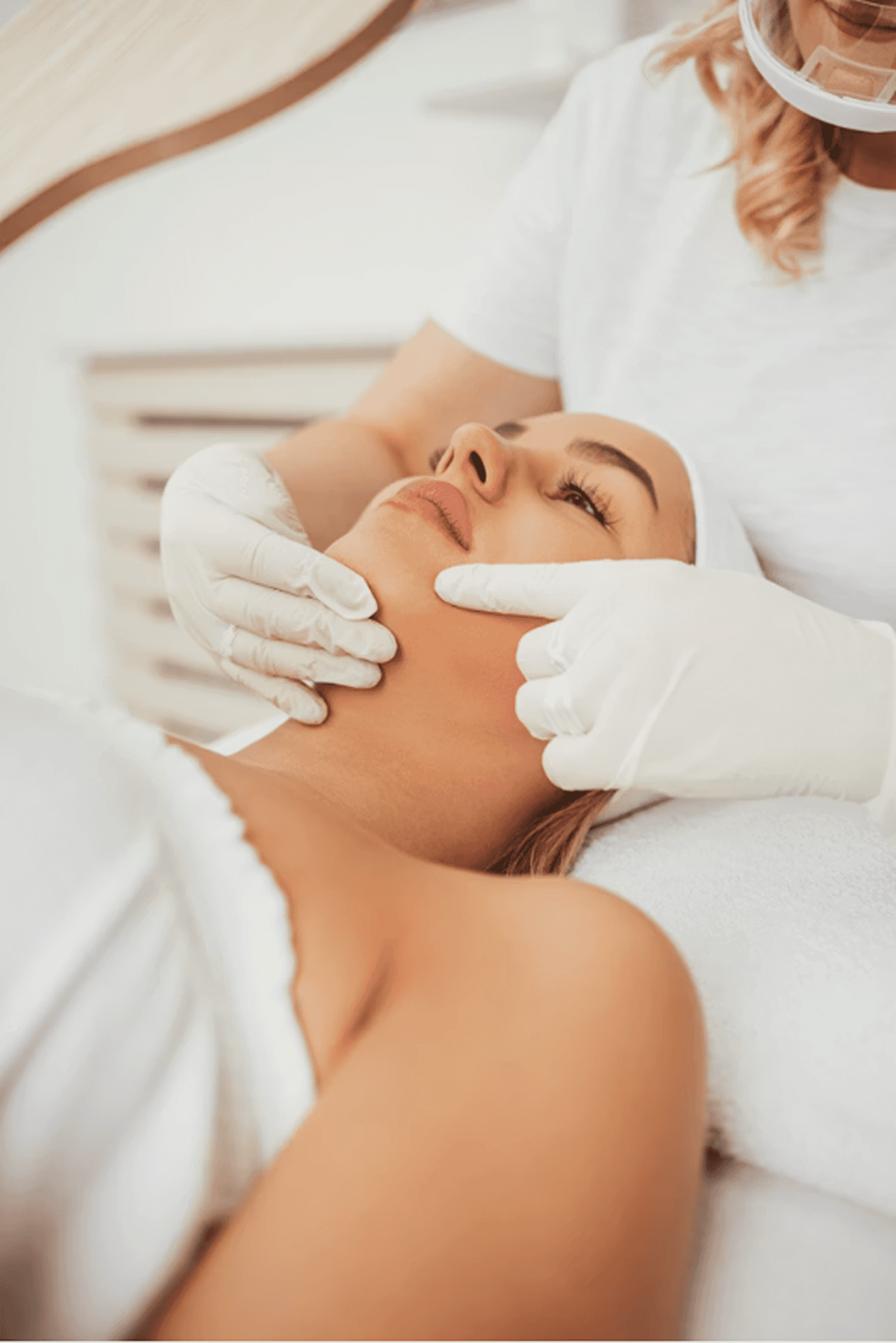 Portrait of a woman with long red hair and closed eyes, gently touching her face with both hands