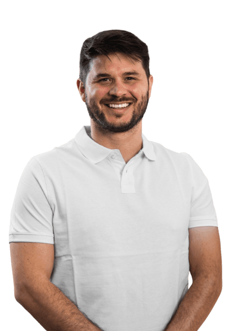 A medical professional smiling and standing in front of the camera