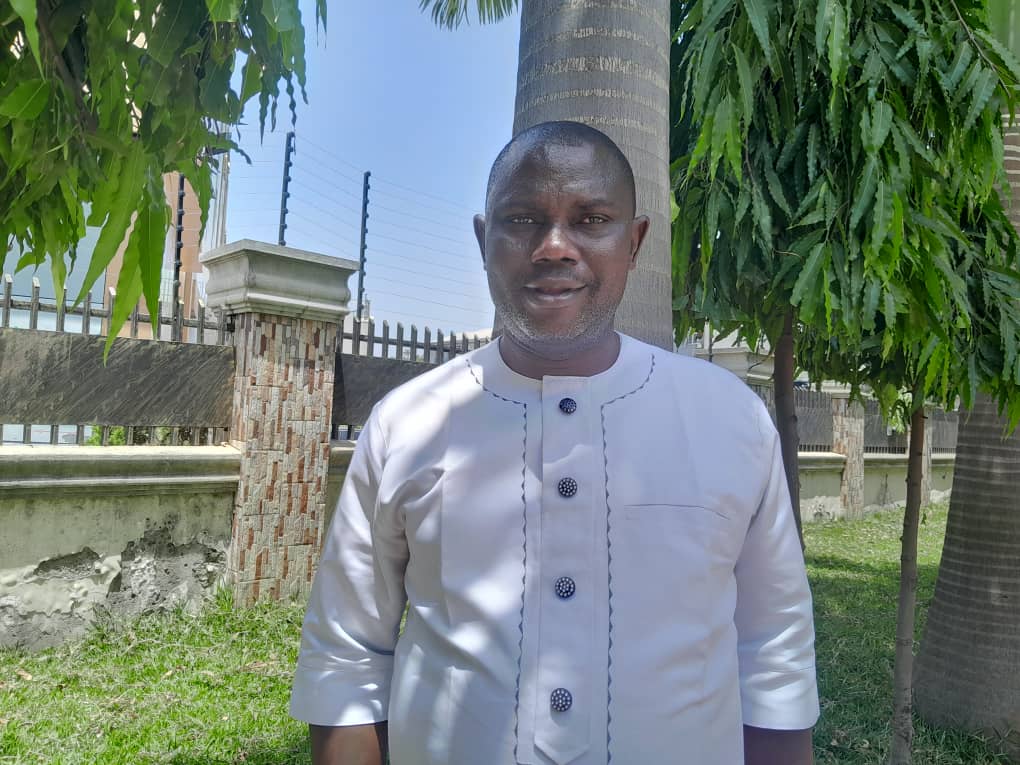 man in black suit jacket holding white ceramic mug
