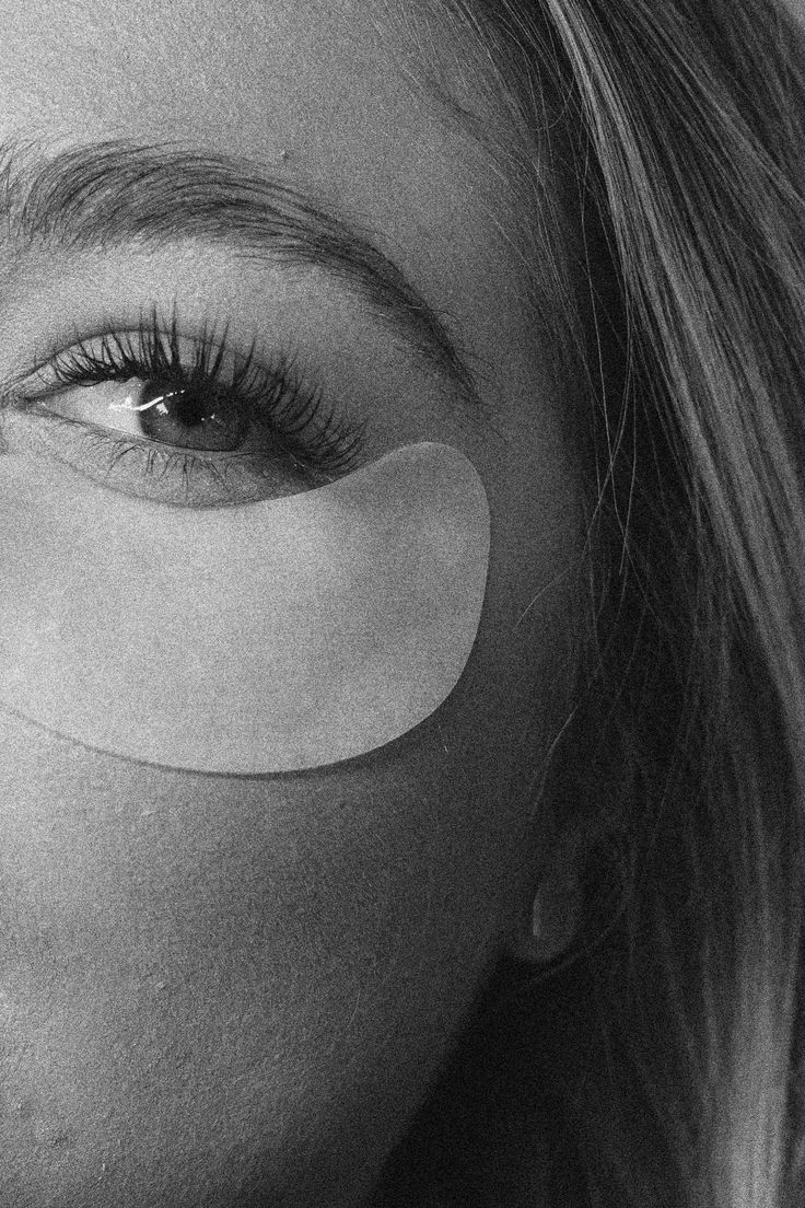 A person lying on a massage table, their face covered with a towel, bathed in warm golden light. The setting exudes relaxation and comfort.