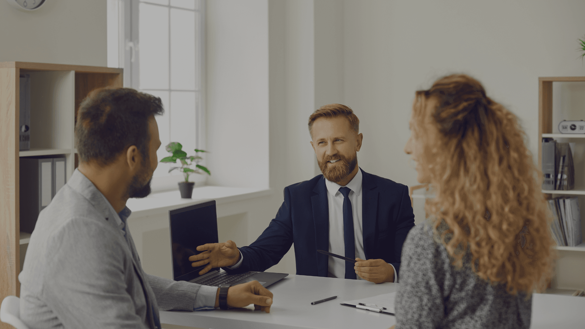 Hand holding a sleek black smartphone or mobile device against a light background