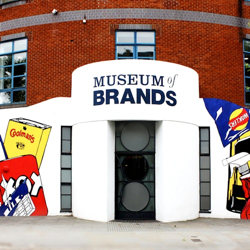 磚石建築外 facade,上面有 "品牌博物館" 的標誌,周圍環繞著多彩的品牌產品圖形。