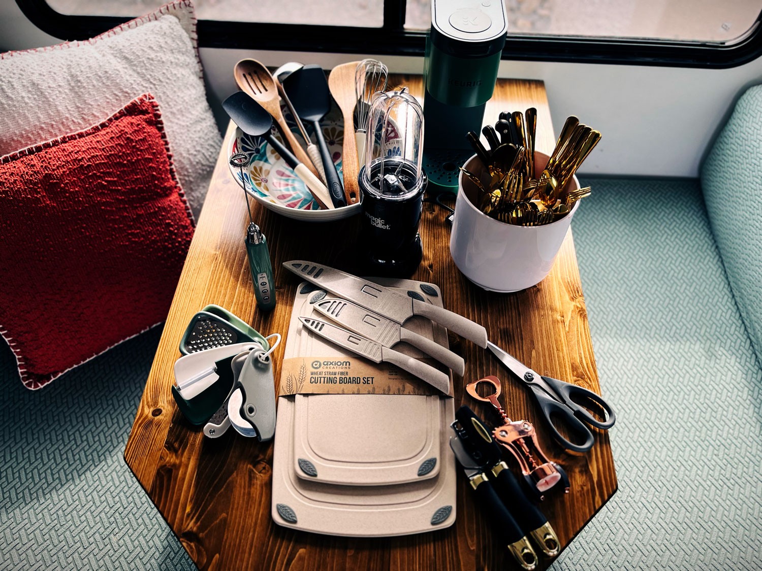RV kitchen interior with white cabinets, wooden countertops, gold faucet, and stove.