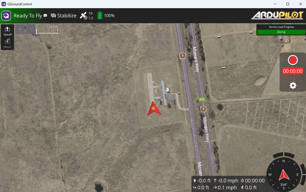 QGroundControl interface showing an aerial map view with a drone positioned at a waypoint near a highway, displaying flight status and telemetry data.