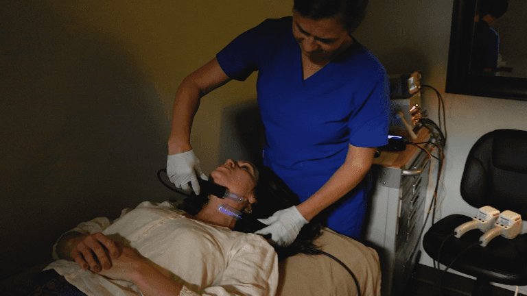 Practitioner performing Electro-Lymphatic Therapy on client in healing room