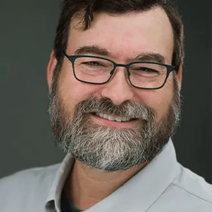 Smiling man with glasses and a beard.