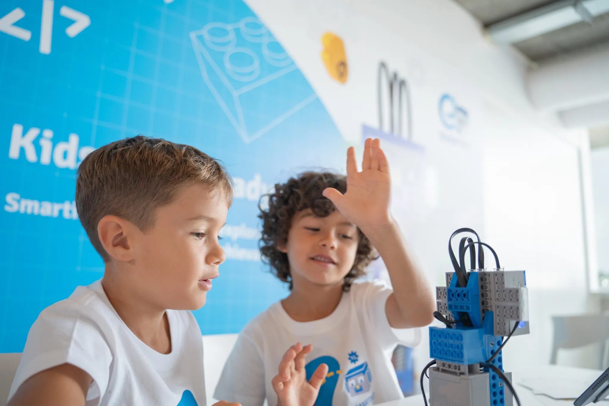 Deux enfants apprennent la robotique avec un kit LEGO dans un atelier de programmation pour enfants.