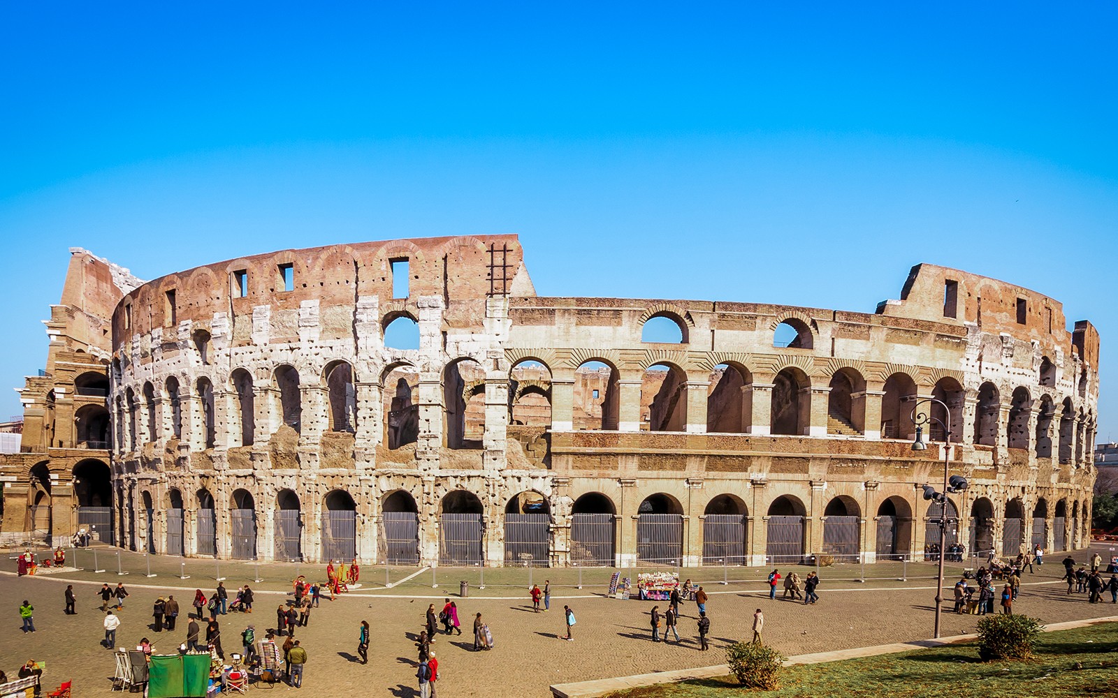 રોમના કોલોસિયમમાં પ્રવાસીઓ માર્ગદર્શિત પ્રવાસમાં બાહ્ય તપાસતા.
