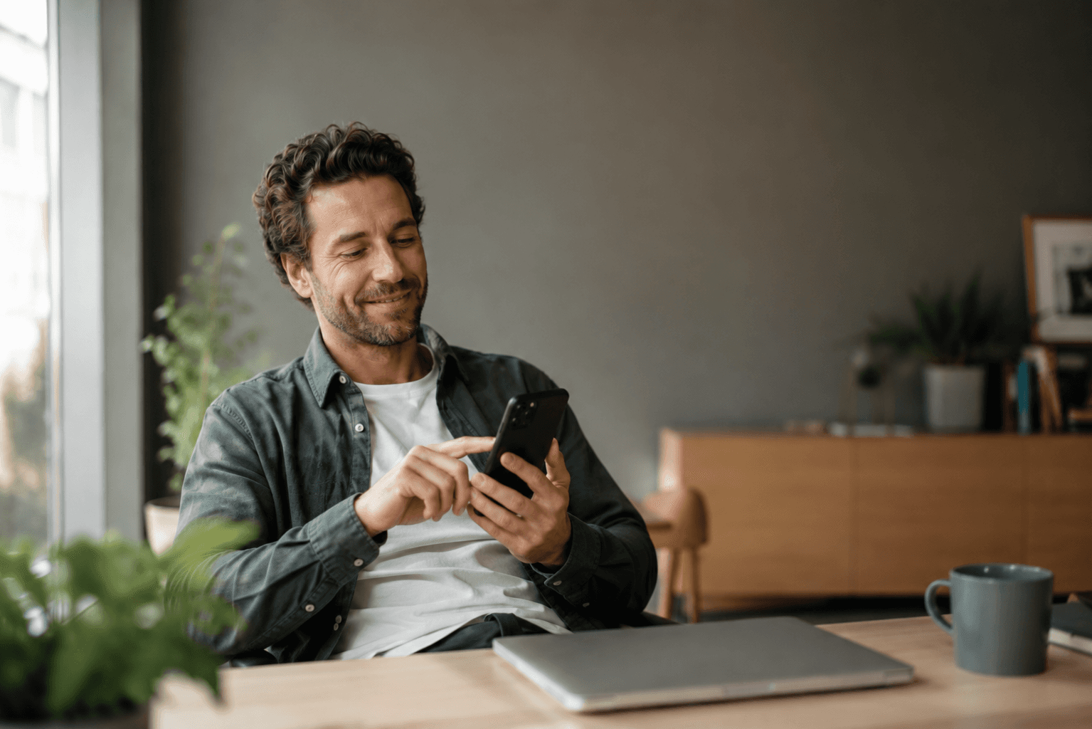 woman holding a phone and man looking at the phone. both are smiling