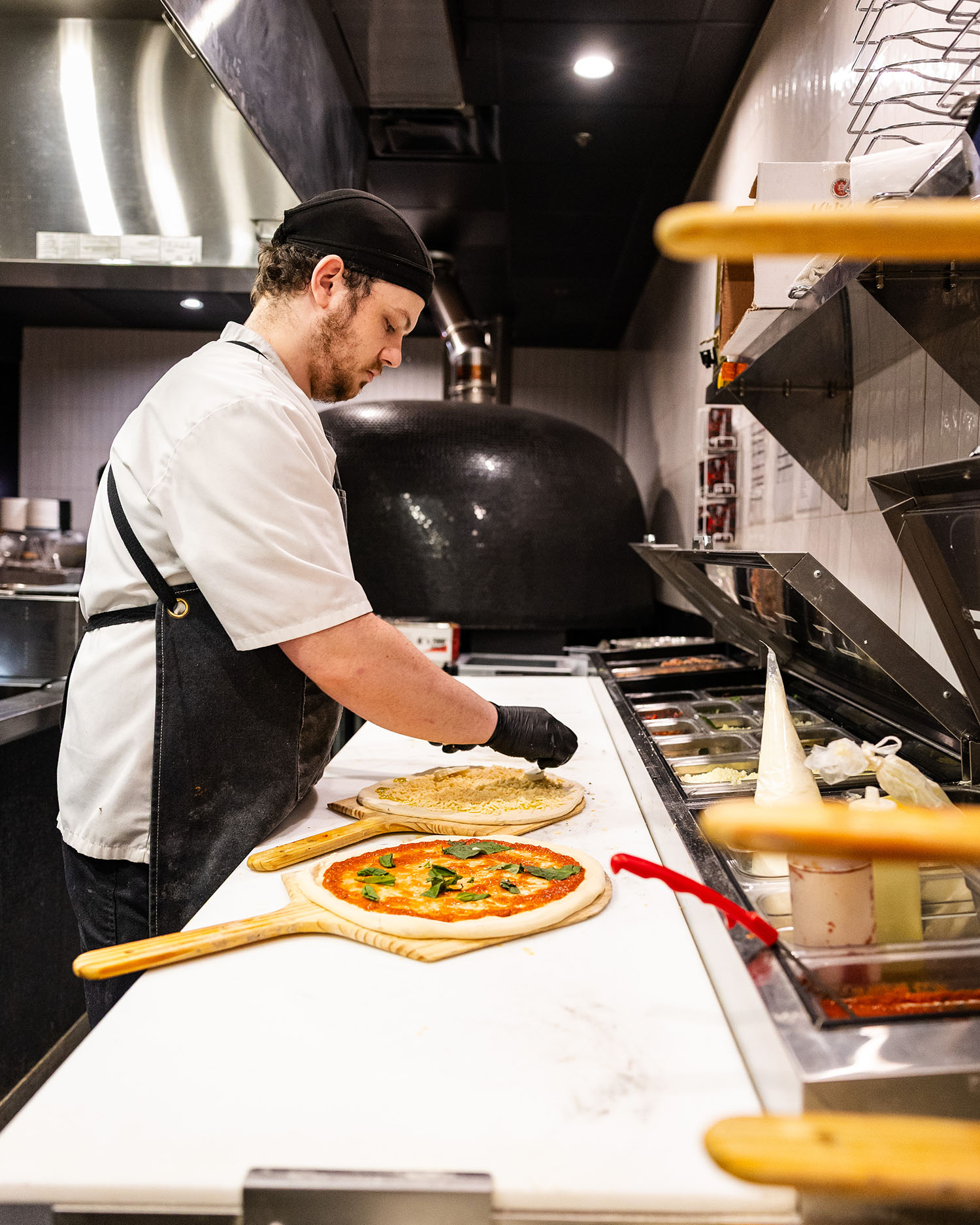 Wooden Paddle chef preparing pizza in kitchen behind the scenes La Grange IL