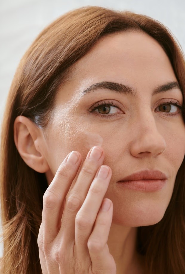 A woman in a straw hat stands in the grass