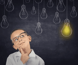 A person standing in front of a blackboard with hanging lanterns.