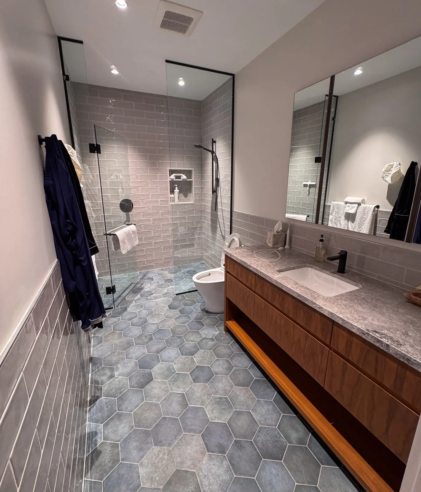 beautiful modern washroom with large floor to ceiling glass shower and custom cabinetry.
