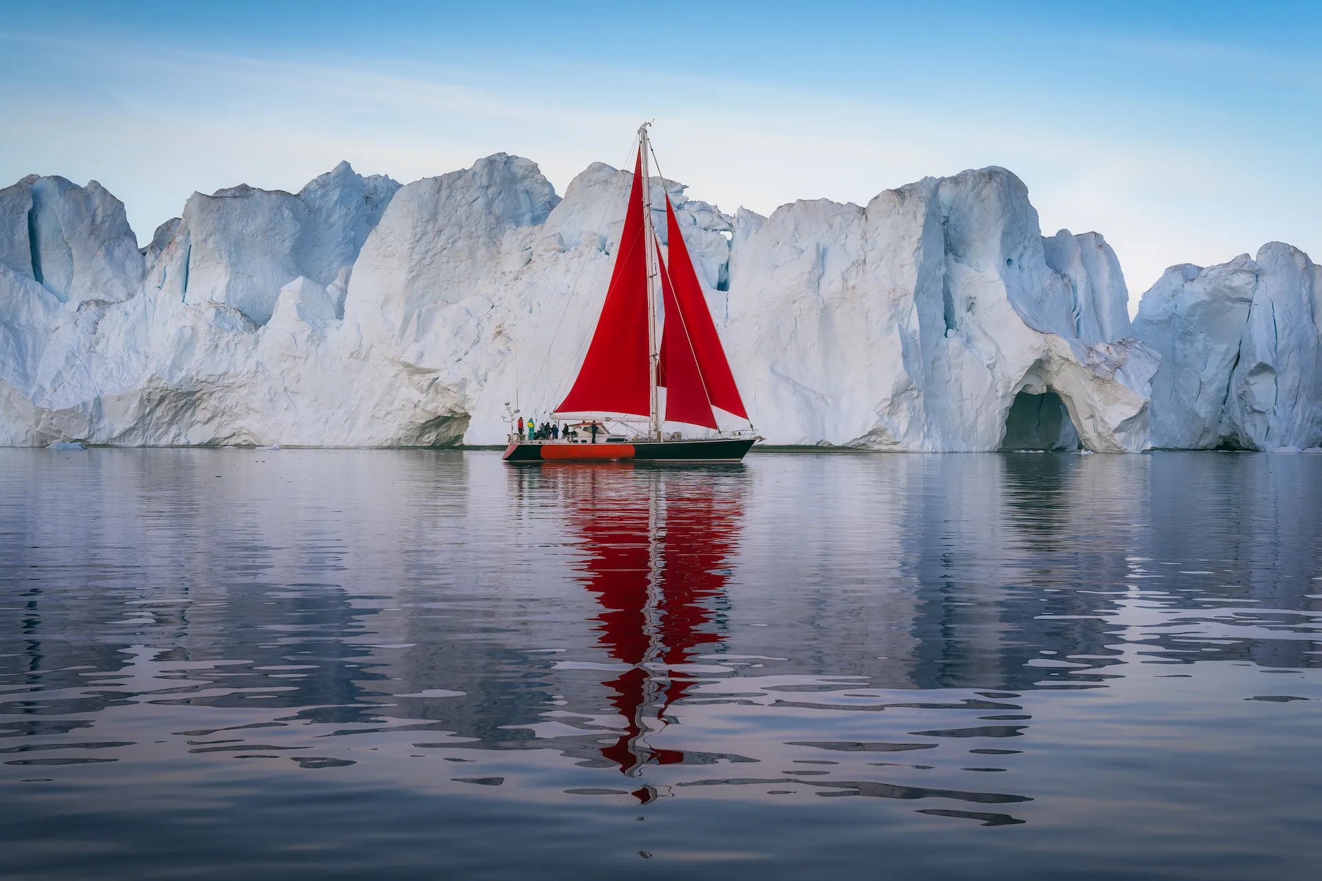 Velero rojo navegando en la bahia de Disko en Groenlandia