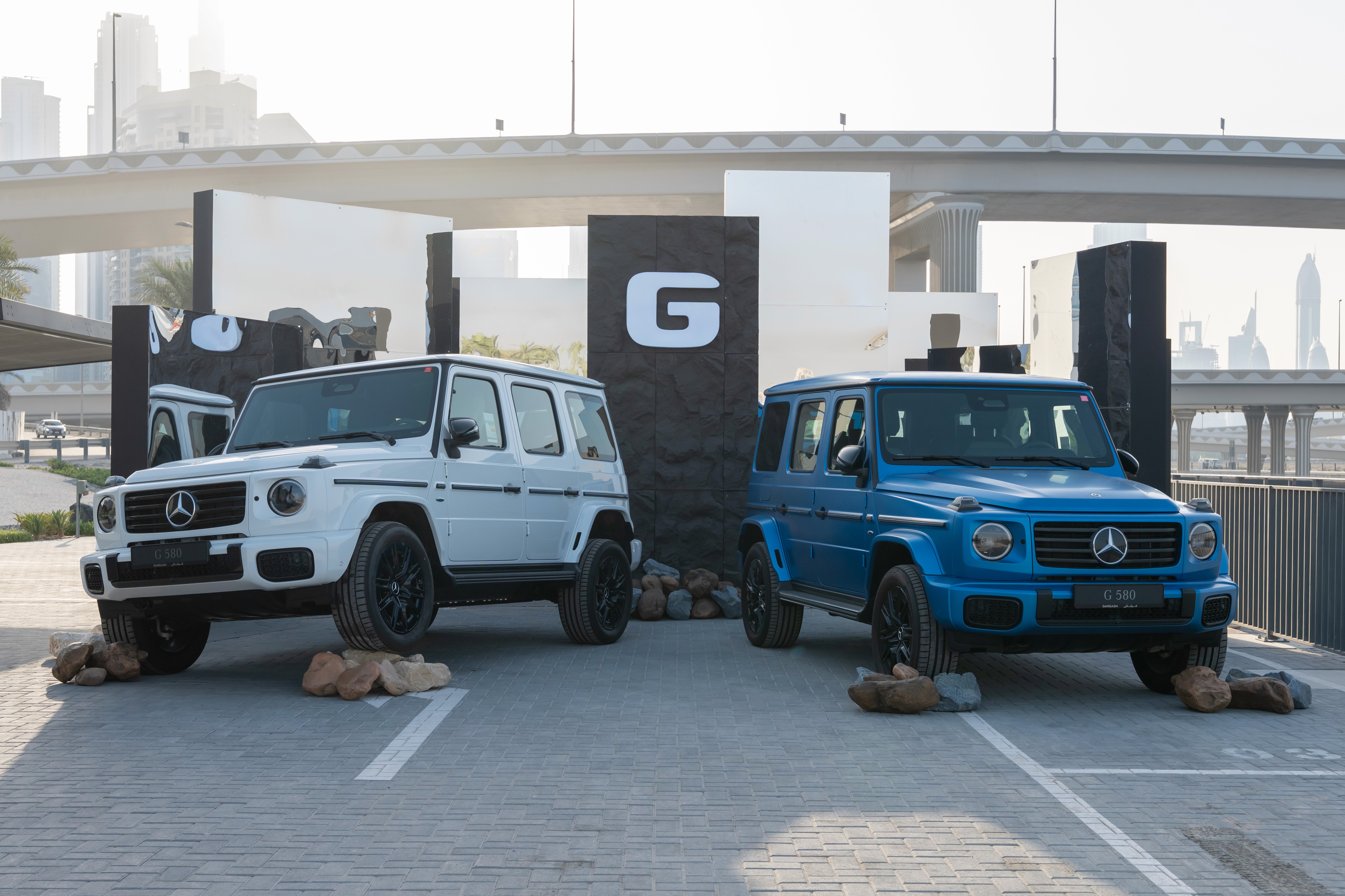 Woman looking at a computer screen in warm natural light, focused and thoughtful, with sunlight casting soft shadows on the wall behind her.