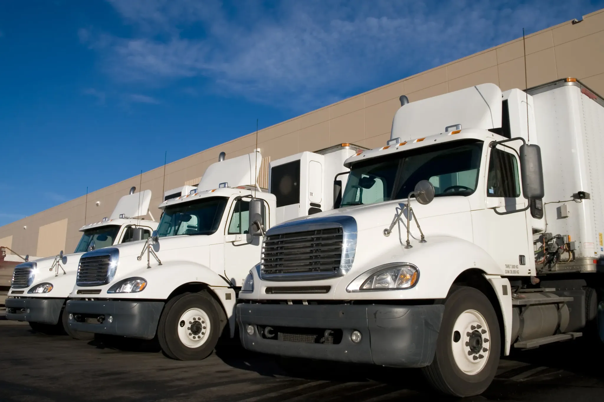 Semi trucks lined up at a warehouse for commercial fleet and logistics operation