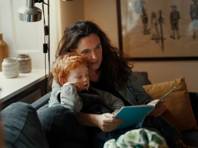 Madre con su hijo pequeño leyendo un libro: seguro de vida con enfermedad previa o cáncer superado
