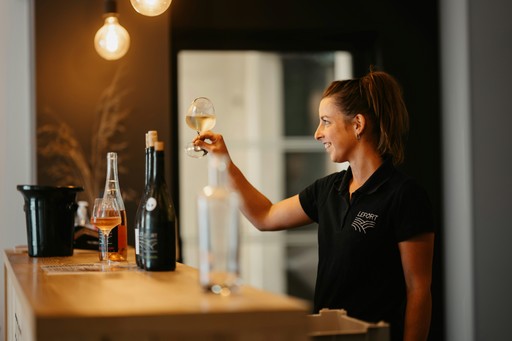 a woman is holding a glass of wine