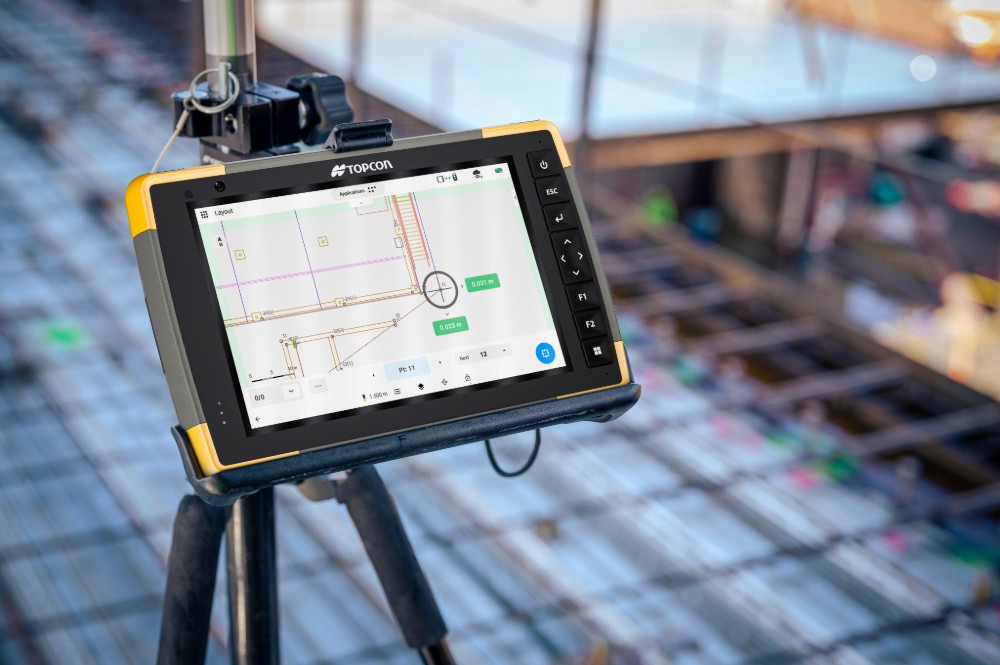 Topcon data collector displaying a 3D site model during layout and grading verification for driveway and roadway construction.