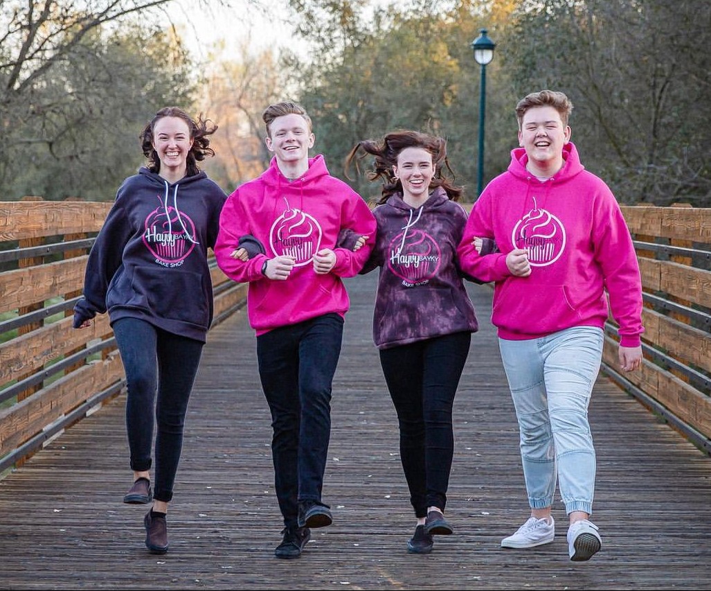 Smiling barista holding green cup at coffee machine