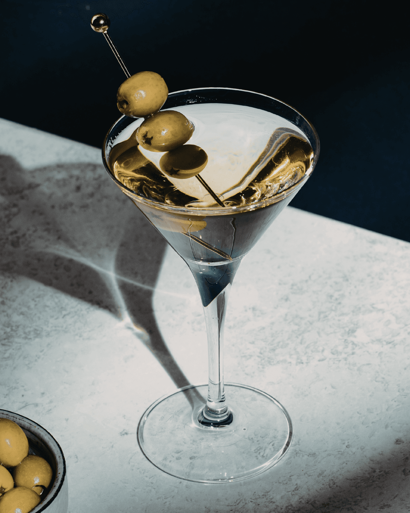 A woman in a trench coat on a grassy hill at twilight