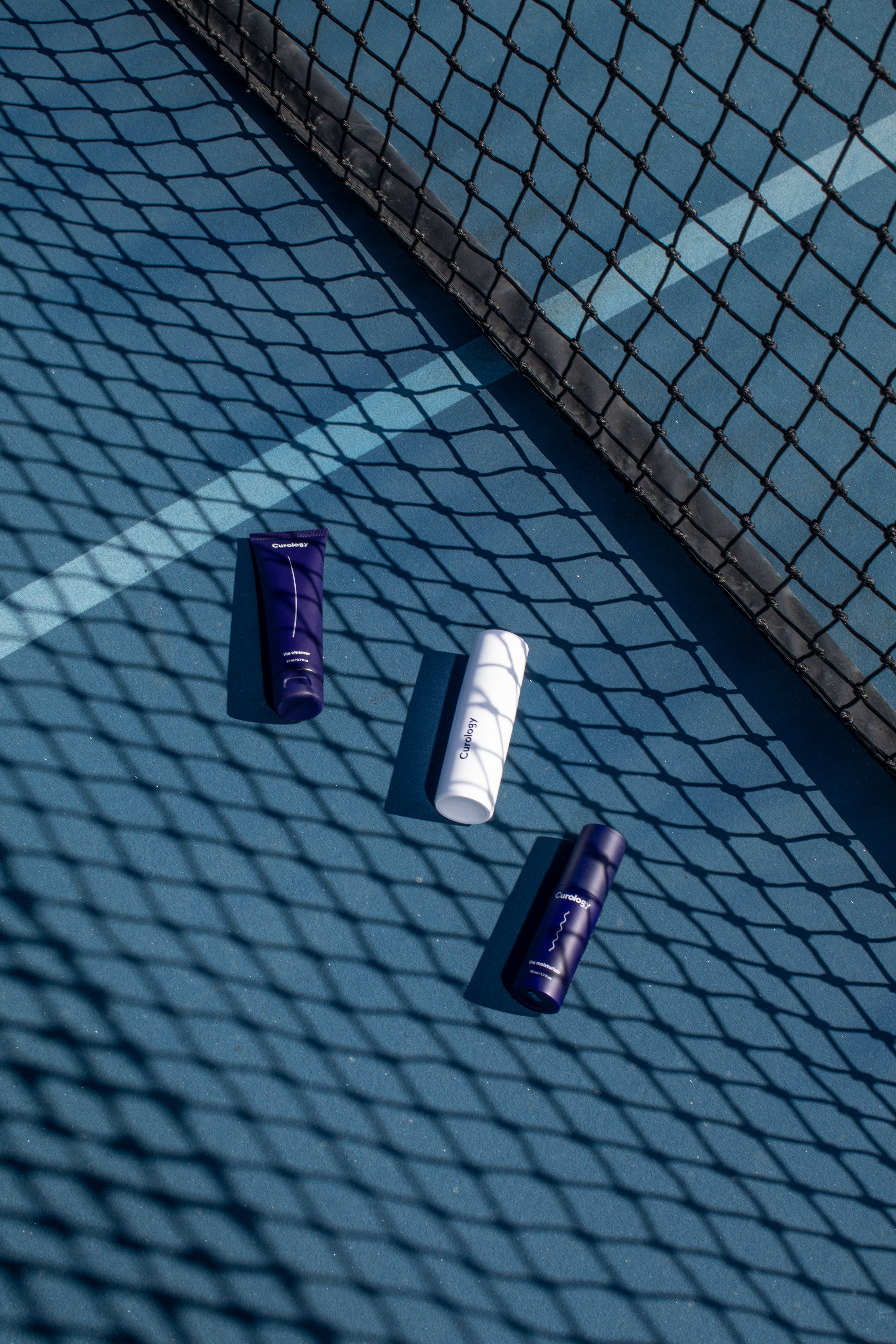 A tenis court with 3 containers on the ground