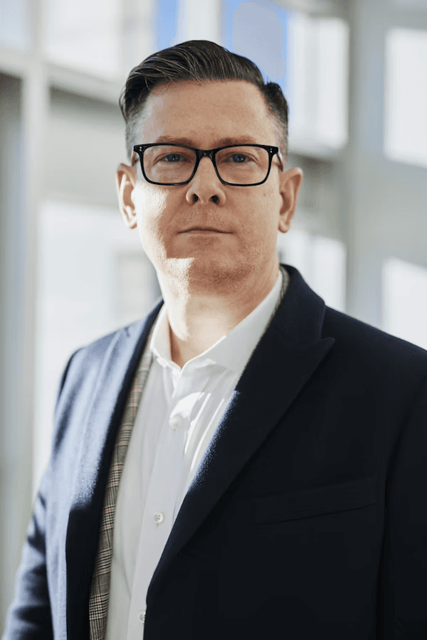 Professional man wearing glasses in a bright office.