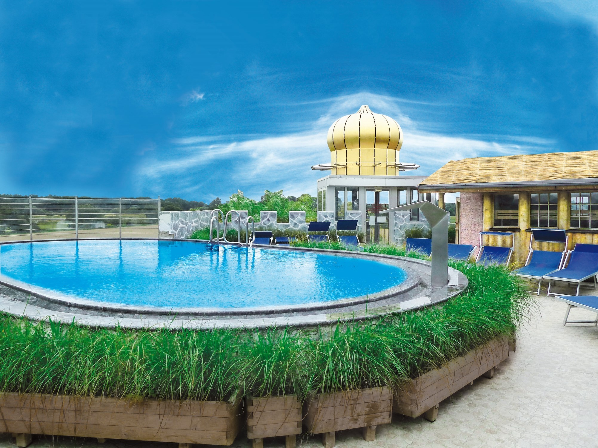 Large house with a wrap-around balcony overlooking a lit pool and deck at night.
