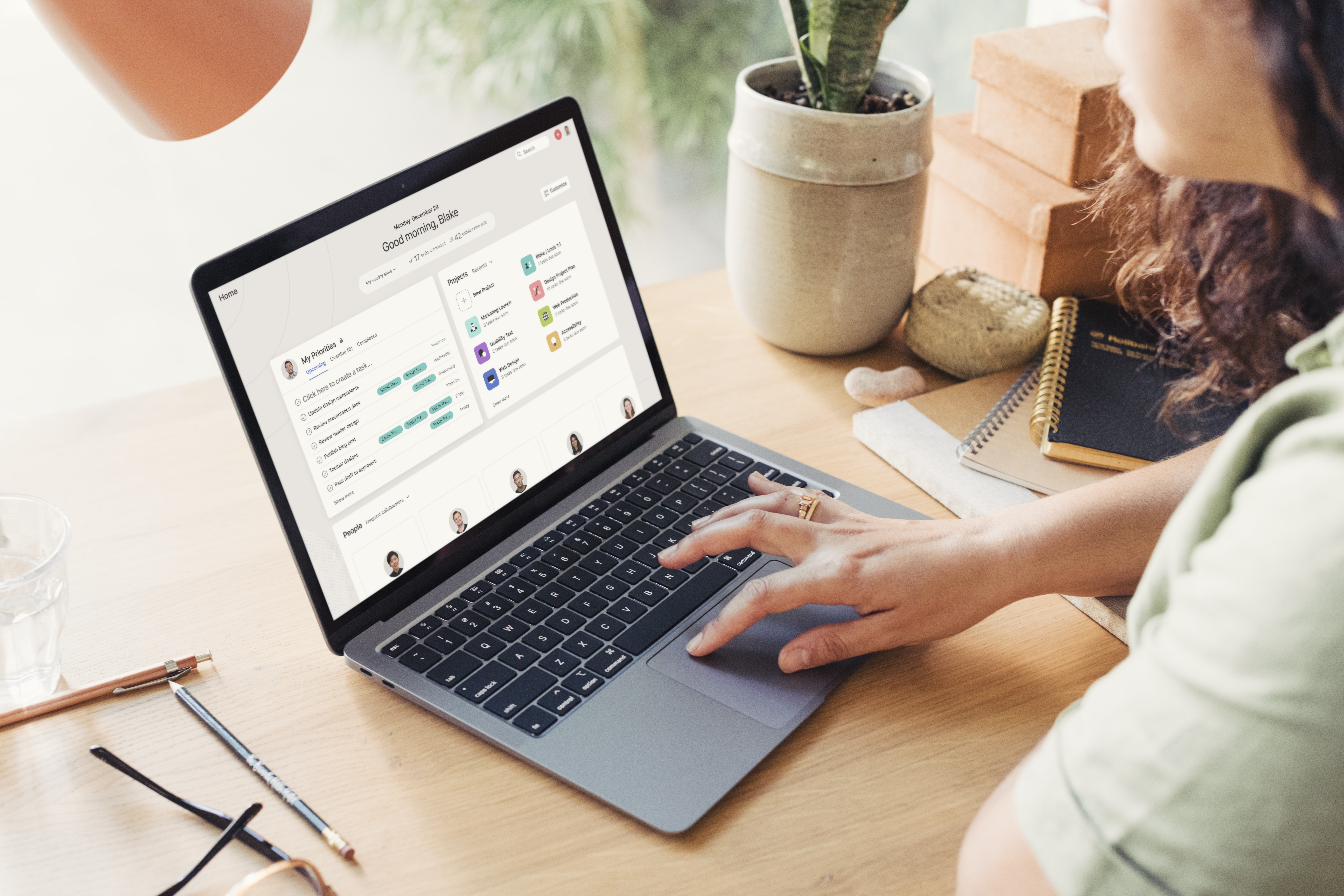 Two people are seated at a table, discussing a document displayed on a laptop screen.