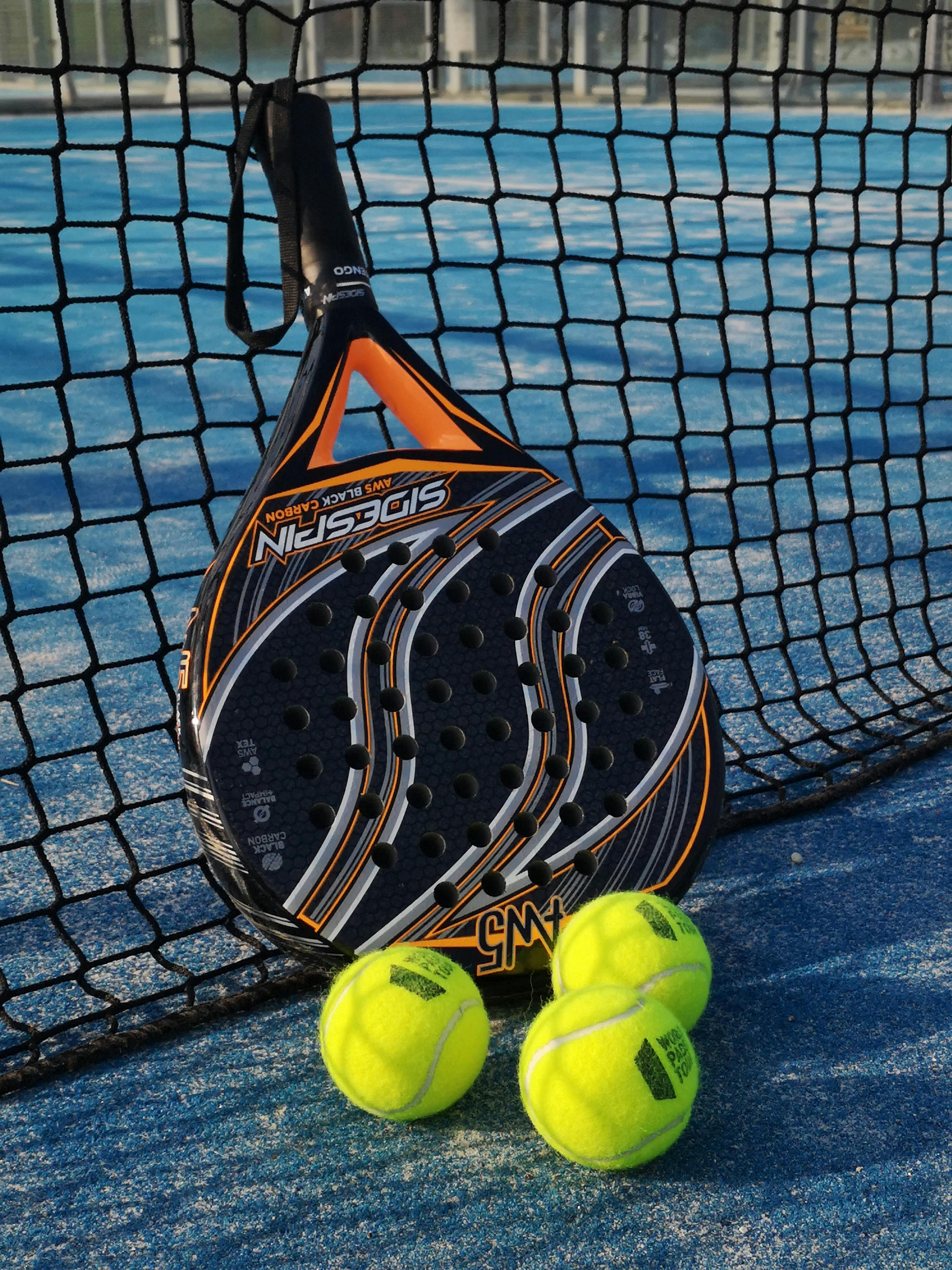 Padelracket leunt tegen het net op een padelbaan in Barcelona.