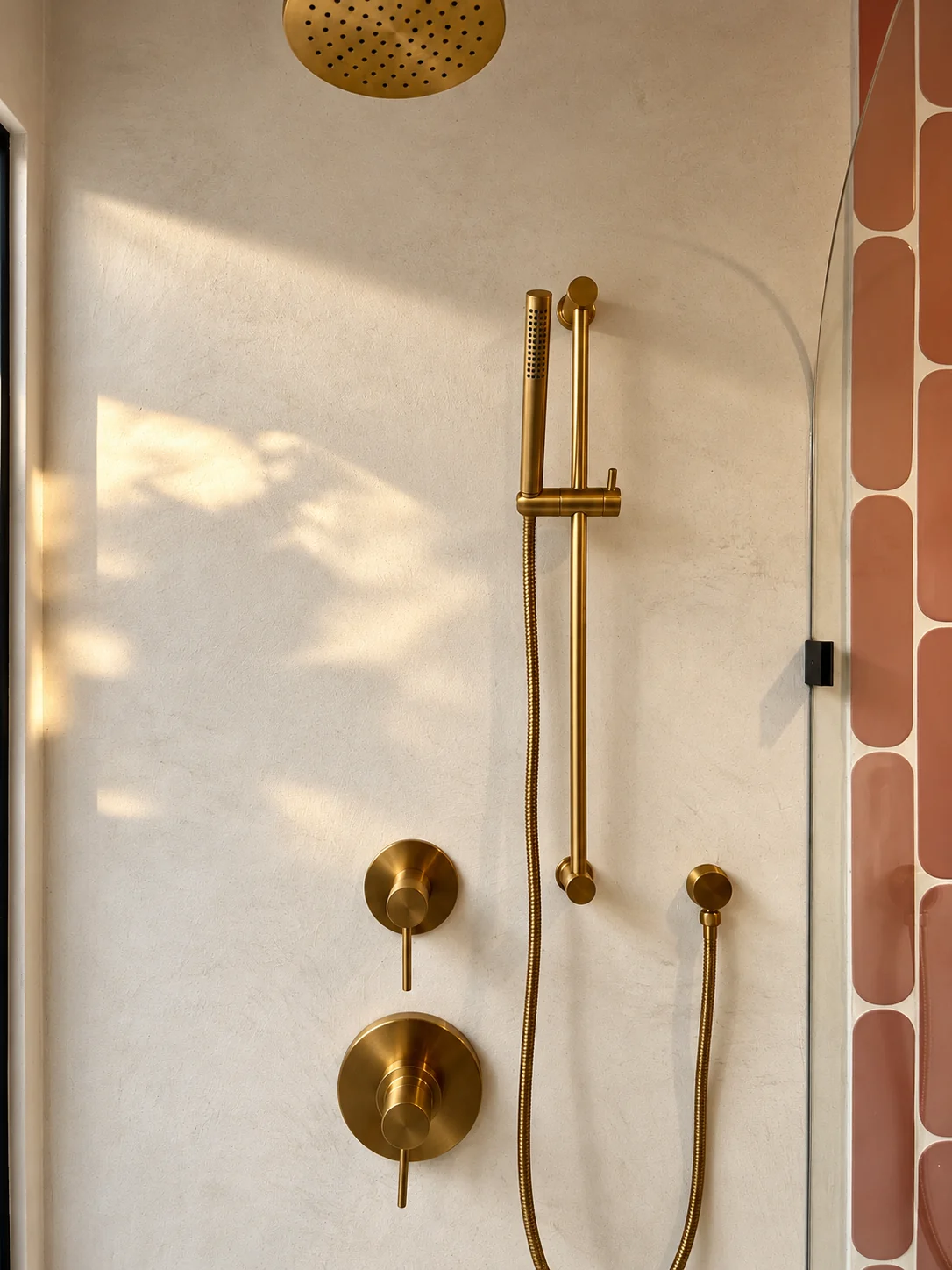 microcement shower, water resistant plaster, brass hardware